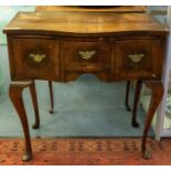 A Queen Anne style mahogany crossbanded serpentine front lowboy, matched veneer top slightly