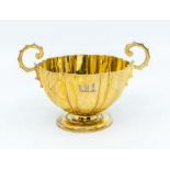 An Arts & Crafts silver gilt fluted two handled cup, C scroll handles with stud decoration,