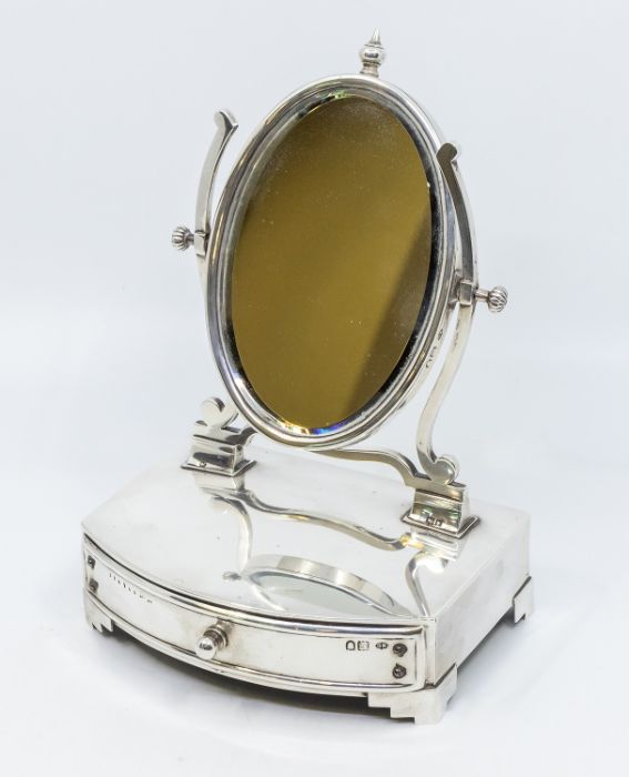 An Edwardian silver mounted dressing table mirror, oval mirror with central finial, fitted velvet