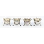 A set of four Edwardian silver salts, flared rims on three shell and trefid feet, hallmarked by