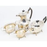 A George V silver four-piece tea set comprising teapot, hot water pot, milk and sugar, flared wavy