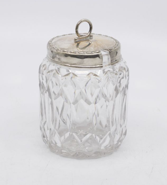 A George V silver mounted cut glass condiment jar, the silver cover with beaded rim and wriggle