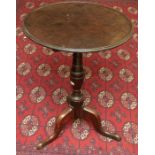 A George III mahogany tilt-top tripod table, the dished top above a turned tapered column, three