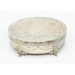 An Edwardian oval silver jewellery box, the body and cover engraved with Neo-Classical decoration,