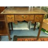 A George III oak lowboy, the moulded top above three drawers, swing handles, square legs, approx