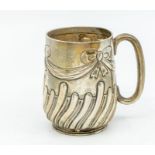 An Edwardian silver Christening mug, the body chased with ribbon tied swags above wyvern fluted