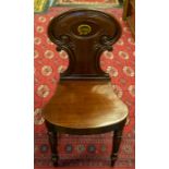 A Victorian mahogany hall chair, shaped and carved back with painted monogram, shaped seat, raised