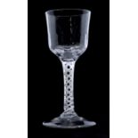 An 18th century wine glass, slightly faceted bowl, spiral gauze alternating with spiral tape air-