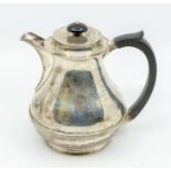 A George VI silver hot water jug, pear shaped body with ribbed section, ebonised handle and