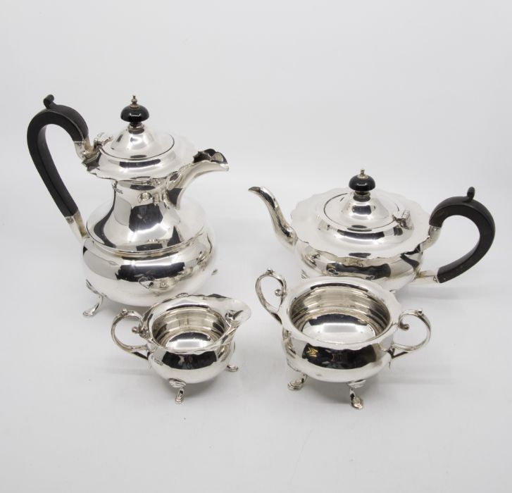 A George V plain silver four piece tea service to include: teapot, hot water jug, sugar bowl and