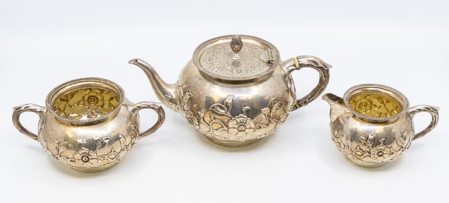 A Victorian Aesthetic silver three piece tea service, comprising teapot, milk jug and sugar bowl,