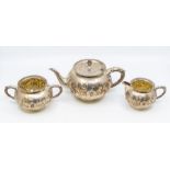 A Victorian Aesthetic silver three piece tea service, comprising teapot, milk jug and sugar bowl,