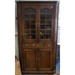A 19th century oak floorstanding corner cupboard, moulded cornice above a pair of astral glazed