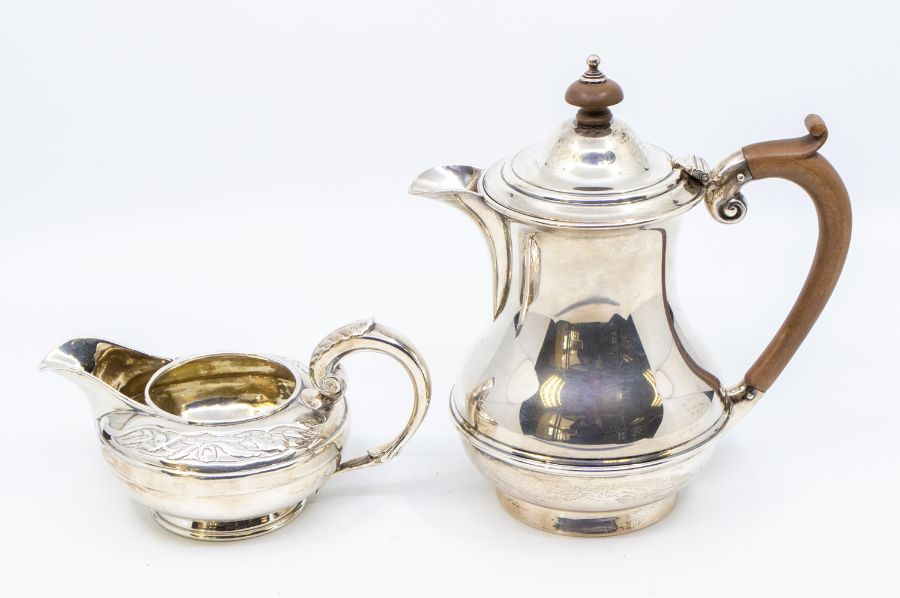 A William IV silver cream jug, the border chased with flowers, hallmarked by Edward Barton,
