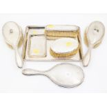 A George V silver mounted five piece dressing table set to include: pair of brushes, clothes