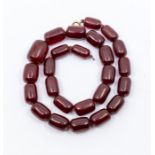 A cherry amber necklace, comprising barrel shaped beads from 30 x 13mm to 15 x 10mm, length approx