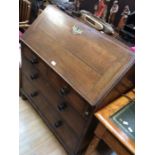 A George III oak bureau; two above and two drawers, knob handles, drop down writing top, on