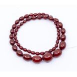 A cherry amber bead necklace, comprising oval graduated beads, the largest approx 18 x 24mm, the