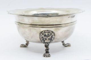 A Georgian style silver sugar bowl, wavy rim above upper rib, on three lion's head and paw feet,
