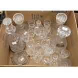 A collection of cut crystal to include four decanters, one in a silver hallmarked coaster, one