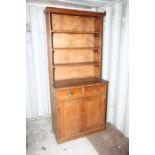 A late 19th Century pine and elm open bookcase, the upper section fitted with three fitted shelves,