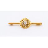A diamond and gold brooch, comprising an old cut diamond set to the centre, approx 0.25ct, further