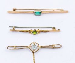 An  Edwardian aquamarine and half pear gold bar brooch, the target centre set with a round cut