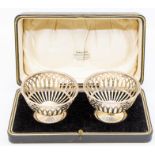 A pair of George V silver reticulated circular bon bon dishes, weighted, hallmarked by Adie