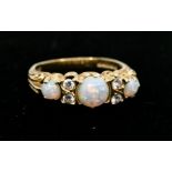 A Victorian style 18ct gold three stone opal ring accented with four brilliant cut diamonds, size N,