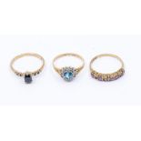 Three 9ct gold rings including a blue topaz and cubic zirconia ring size M, a sapphire and diamond
