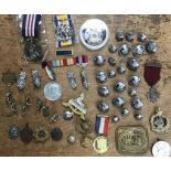 Collection of military items, buttons, reproduction medals, cap badges and other items.