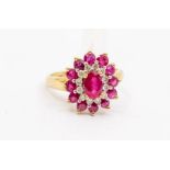 A ruby and diamond set oval 9ct gold cluster ring, set to the centre with an oval ruby, within a