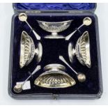 A set of four Victorian silver boat shaped salts, with wyvern fluted ornate lower section, gilt