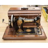 An Edwardian "Jones Family CS" painted cast iron sewing machine, serial number: 241232, in wooden