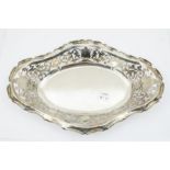 An Edwardian silver lozenge shaped bowl, the raised sides pierced with scrolling foliate decoration,