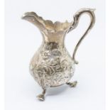 A Victorian silver pear shaped cream jug, chased with floral decoration, wavy rim, S-scroll