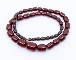 A cherry amber necklace, comprising oval beads the largest approx  30 x 22mm, the smallest approx 12