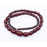 A cherry amber necklace, comprising oval beads the largest approx  30 x 22mm, the smallest approx 12