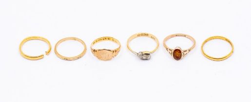 Six gold rings, including two 22ct gold bands, (one cut through) weight approx 4gms, an 18ct three