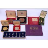 A collection of commemorative coins to include a Staffordshire miniature on a chain and a set of toy