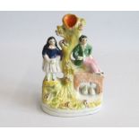 A small Staffordshire spill vase with a man sitting on a bridge and a lady standing Circa: 1850