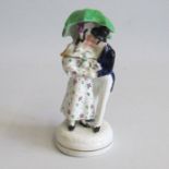 A Small Staffordshire figure of a gentleman and lady kissing under an umbrella Circa: 1830 Size: