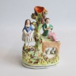 A small Staffordshire spill vase with a man sitting on a bridge and a lady standing Circa: 1850