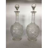 A pair of early 20th century glass decanters, fluted necks, ovoid body with faceted shoulder. cross