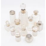 A collection of late 19th and early 20th Century cut glass scent and toilet bottles, with silver