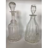 Two clear glass decanters; one bell shape with two rings on neck, sinuous lines, ground pontil
