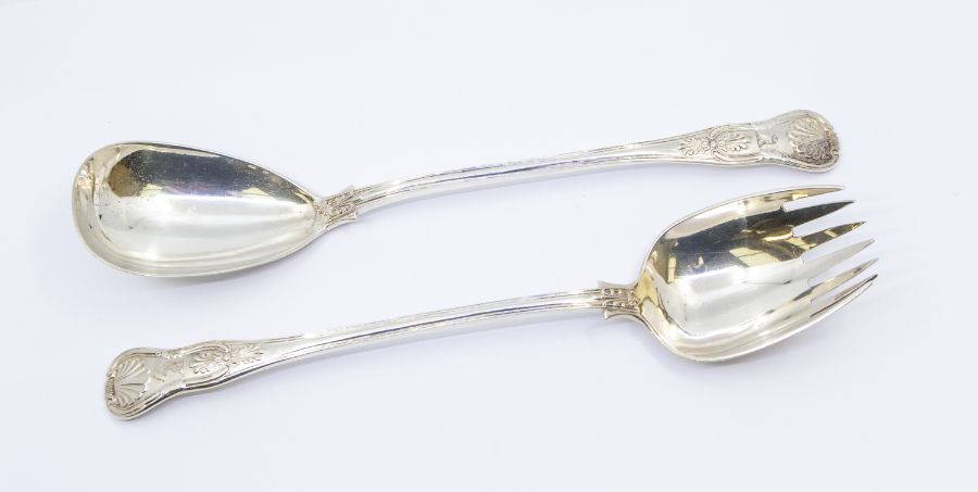 A pair of Victorian Irish King's pattern silver servers, each handle engraved with a crest,