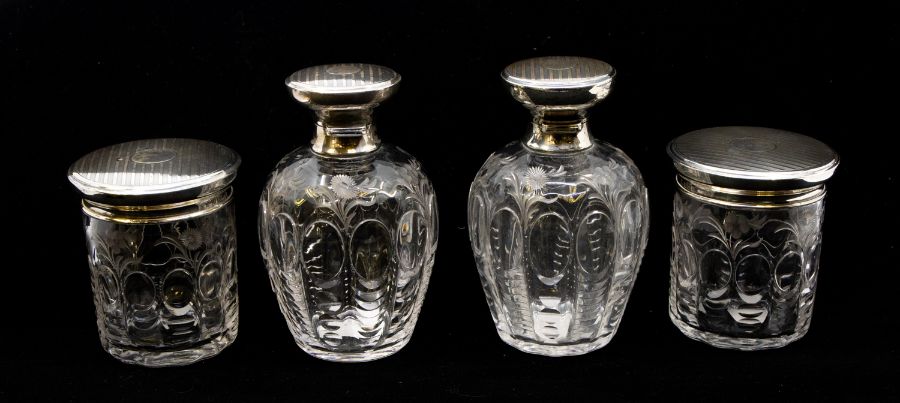 A matched four piece George V silver mounted and cut glass toilet set comprising two large bottles