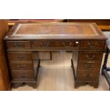 A reproduction pedestal desk in three parts, with brown writing pad