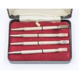 A set of four early 20th Century American silver engine turned Bridge pencils, each terminal with